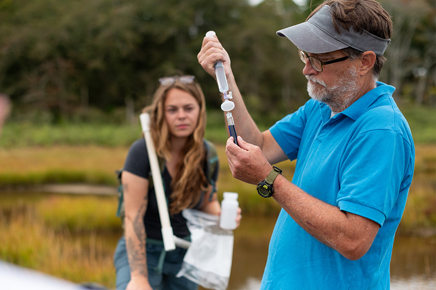 two people taking water samples